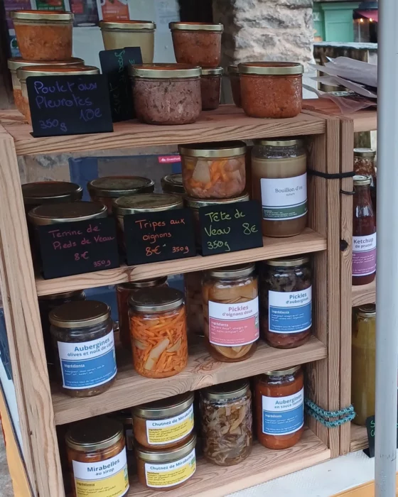 Les bocaux de Loïc Vauclin sur son stand du marché de Najac : tête de veau, tripes aux oignons, terrine de pieds de veau, bouillon d'os, pickles et chutneys
