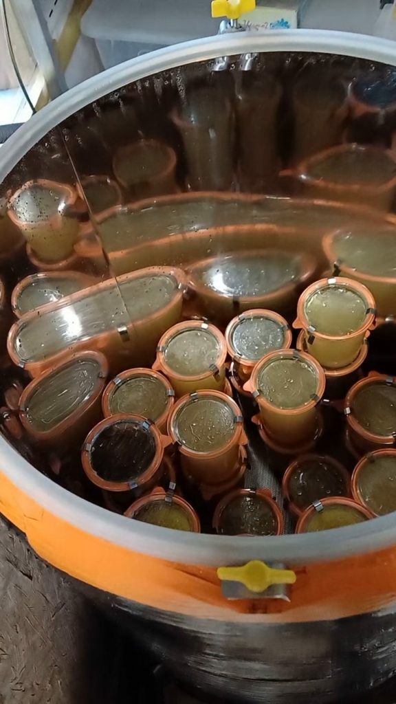 Bocaux et bouteilles de bouillon dans un pasteurisateur vapeur fait maison