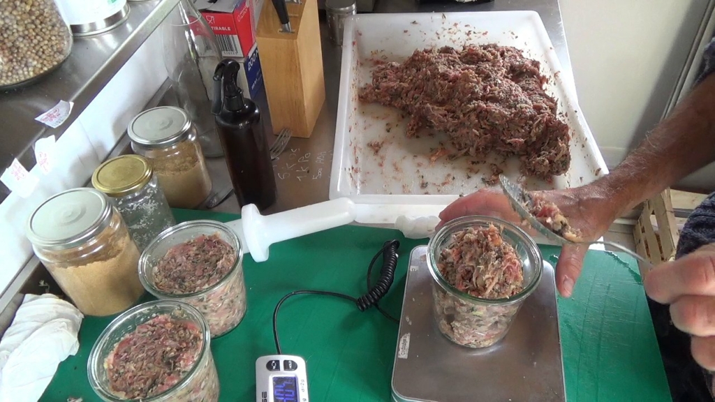 Remplissage d'un bocal Weck de farce de terrine, posé sur la balance